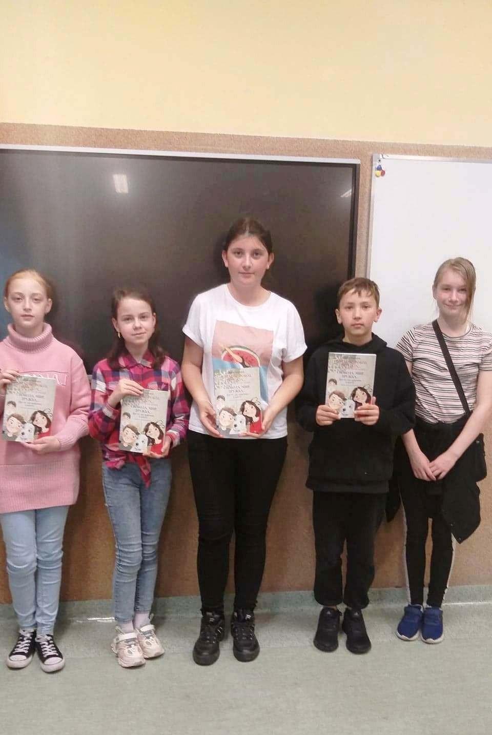 Uczniowie z książką napisaną w wersji polsko – ukraińskiej pt. Wolność, pokój, przyjaźń